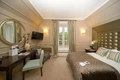 a hotel room with a bed and a desk and a mirror at Isle of Eriska Hotel Spa & Island in Benderloch