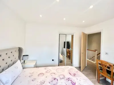 a white bedroom with a bed and a room at Paradise on earth in Garthamlock