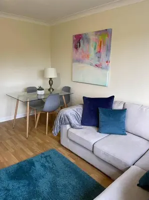 a living room with a couch and a table at 2 bed city centre modern flat in Edinburgh