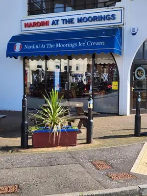 a restaurant with a blue awning and a table at Apartment - Largs - Sleeps 4 - Pet Friendly in Largs