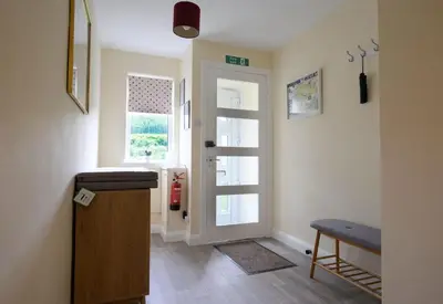 a hallway with a door with a window and a table at Ardview Cottage in Oban