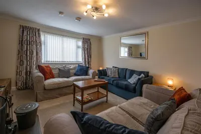 a living room with two couches and a table at Ardview Cottage in Oban