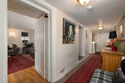 a hallway leading to a living room with a couch at Castle Gogar Cottage in Edinburgh