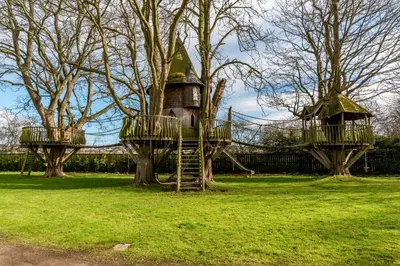 a tree house in a park with two trees at Castle Gogar Cottage in Edinburgh