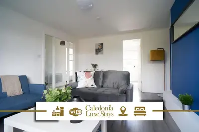 a living room with a couch and a chair at Dunalastair Apartment in Glasgow