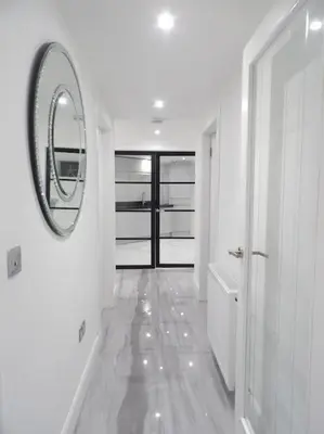 a white bathroom with a mirror on the wall at Modern 3BHK near Edinburgh zoo in Edinburgh