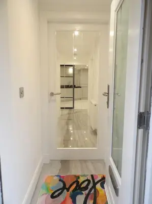 a hallway with a mirror and a rug on the floor at Modern 3BHK near Edinburgh zoo in Edinburgh
