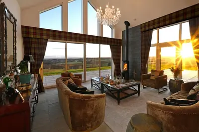 a living room with couches and chairs and a chandelier at Kipney Hunting Lodge in Perth
