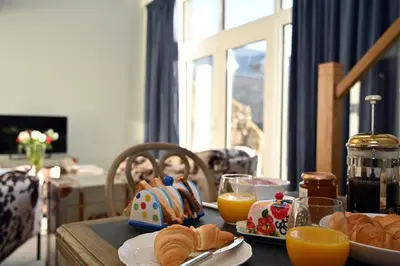a table topped with plates of bread and orange juice at Kipney Hunting Lodge in Perth