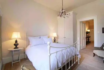 a bedroom with a white bed and two lamps at Home of Joy - 3 bedroom home with private garden in Glasgow