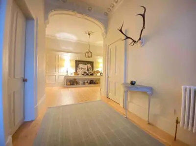 a hallway with a white door and a blue table at Home of Joy - 3 bedroom home with private garden in Glasgow