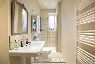 a bathroom with a sink and a toilet and a mirror at Home of Joy - 3 bedroom home with private garden in Glasgow