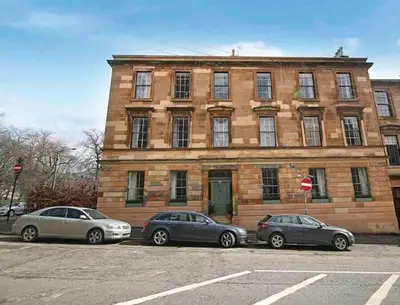 three cars parked in front of a brick building at Home of Joy - 3 bedroom home with private garden in Glasgow