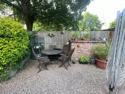 a patio with a table and chairs and a fence at Stunning West End Flat! in Glasgow
