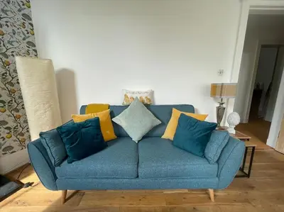 a blue couch with colorful pillows in a living room at Stunning West End Flat! in Glasgow