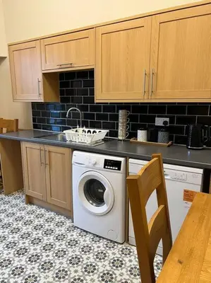 a kitchen with a washing machine and a sink at Luxury Victorian spacious flat in Glasgow