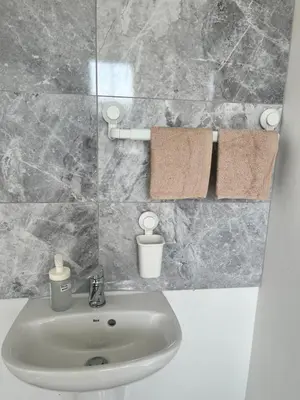 a bathroom with a sink and towels on a wall at Modern Comfy One Bed Apartment - Free Parking in Glasgow