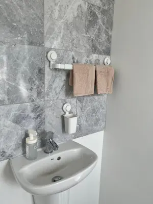 a white sink in a bathroom with marble tiles at Modern Comfy One Bed Apartment - Free Parking in Glasgow