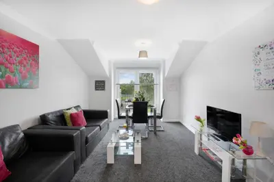 a living room with a couch and a tv at PREMIER - Clydesdale Apartment in Mossend
