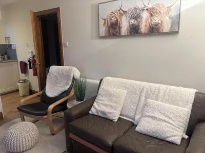 a living room with a couch and two chairs at Morenish Mews Killin Cottage in Morenish