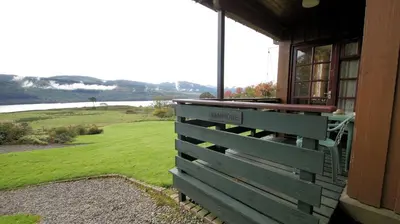 a porch of a house with a view of a field at Morenish Mews Kenmore Cottage in Morenish