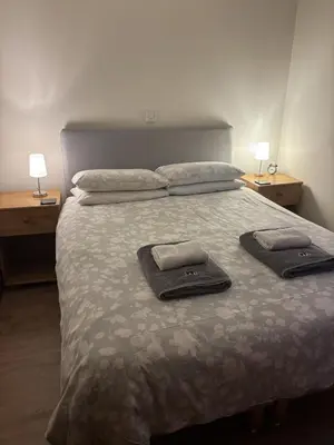 a bedroom with a bed with two towels on it at Morenish Mews Kenmore Cottage in Morenish