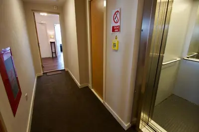 a hallway with a no smoking sign on a wall at Penthouse Apartment in Stirling
