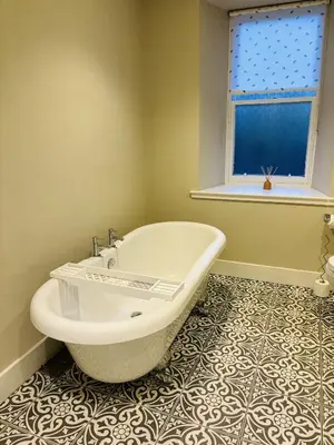a bath tub in a bathroom with a window at Ruchearn in Comrie