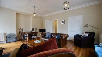 a living room with leather couches and a table at Ruchearn in Comrie