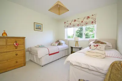 a bedroom with two beds and a dresser and a window at Tomanour in Comrie