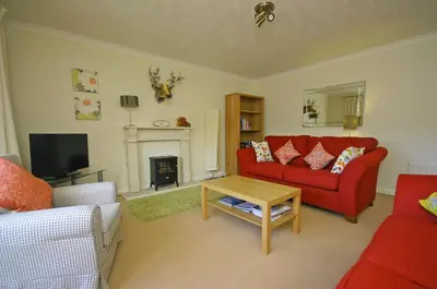 a living room with a red couch and a fireplace at Tomanour in Comrie