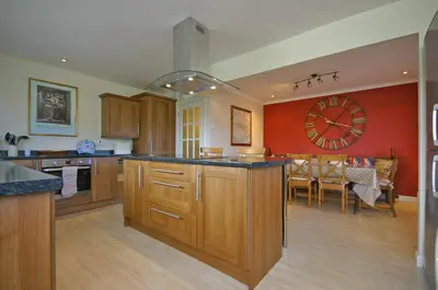 a large kitchen with a large clock on the wall at Tomanour in Comrie