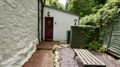 a door to a building with a bench next to it at View Cottage in Lochearnhead