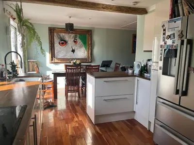 a kitchen with a cat painting on the wall at Bright, comfy and peaceful house in Inverkeithing