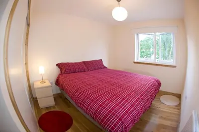 a small bedroom with a bed and a window at Lochleven Seafood Cottage in Onich