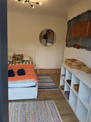 a bedroom with a bed and a mirror on the wall at Private room with terrace and free parking in Edinburgh