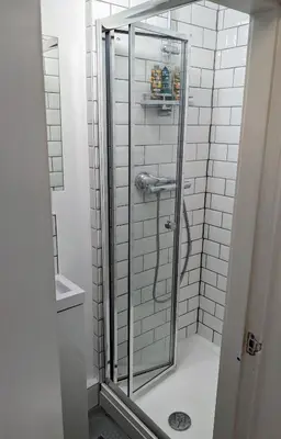 a shower with a glass door in a bathroom at Private room with terrace and free parking in Edinburgh