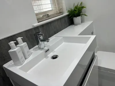 a white bathroom sink with two soap dispensers on it at Premium executive Apartment in Dunfermline in Dunfermline