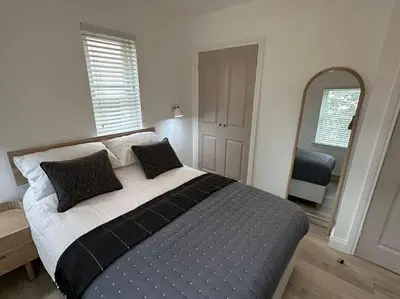 a bedroom with a large bed and a mirror at Premium executive Apartment in Dunfermline in Dunfermline