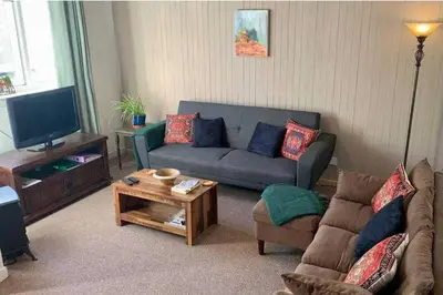 a living room with a couch and a tv at 2 Bed Cottage Sleeps 2 - Parking Pet Friendly in Dunoon
