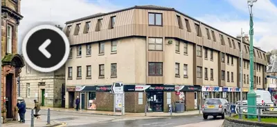 a building on a city street with a arrow sign at 16 Macgregor court, Oban in Oban