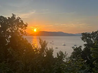 a sunset over a large body of water with boats at Waverley Apartments, Crow's Nest in Gourock
