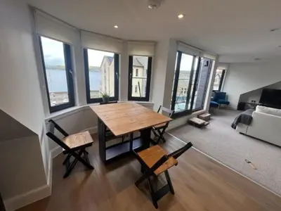 a living room with a table and chairs and a couch at Waverley Apartments, Crow's Nest in Gourock
