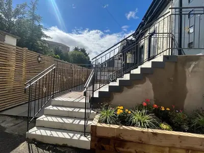 a set of stairs next to a building with flowers at Waverley Apartments - The Wedge in Gourock