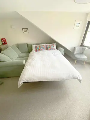 a bedroom with a white bed and a couch at Waverley Apartments - The Wedge in Gourock