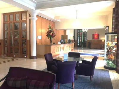 a lobby with a table and chairs in a building at Millennium Hotel Glasgow in Glasgow