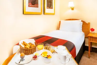 a hotel room with a tray of food on a bed at Millennium Hotel Glasgow in Glasgow