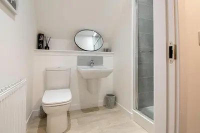 a bathroom with a toilet and a sink and a mirror at Beautiful Glasgow South Home - Pass the Keys in Glasgow
