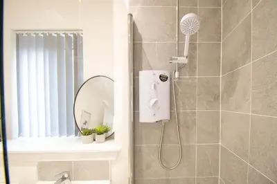 a bathroom with a shower with a shower fan at Beautiful Glasgow South Home - Pass the Keys in Glasgow
