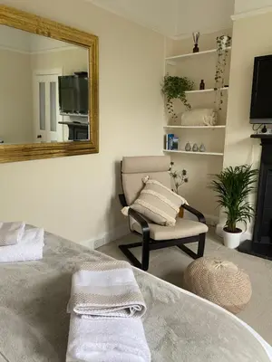 a bathroom with a tub and a chair and a mirror at Tranquil Haven Murrayfield in Edinburgh
